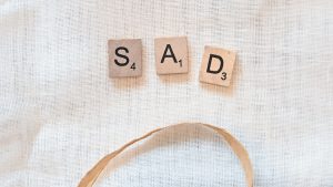 scrabble tiles spelling sad and sad on a white background
